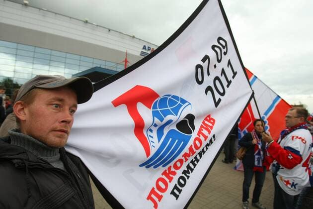 YAROSLAVL, RUSSIA. SEPTEMBER 7, 2012. Fans hold a flag outside the Arena 2000 Stadium during a memorial event for the Lokomotiv Yaroslavl hockey players and coaching staff who died in the September 2011 plane crash near Yaroslavl.  RE107BA1