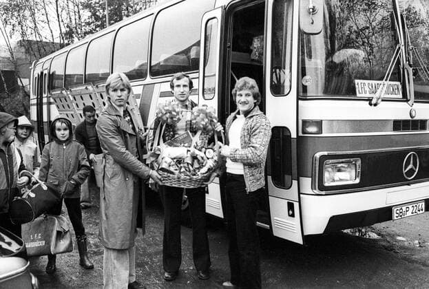 Egon Schmitt (Mitte), Konrad Eickels (re.) und Bernd Förster (alle 1. FC Saarbrücken) mit einem Präsentkorb