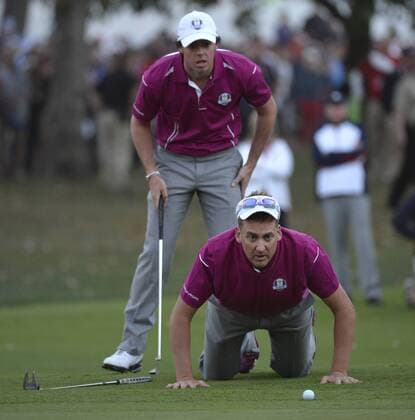 Team Europe s Ian Poulter of England (R) helps teammate Rory McIlroy of Northern Ireland (Nordirland) line up his birdie putt on the 18th hole at the 39th Ryder Cup at Medinah Country Club on September 29, 2012 in Medinah, Illinois. After the second day of play the United States leads Europe 10-6 and needs 4 1 2 points in the final round to win the Ryder Cup.  BKX2012092967
