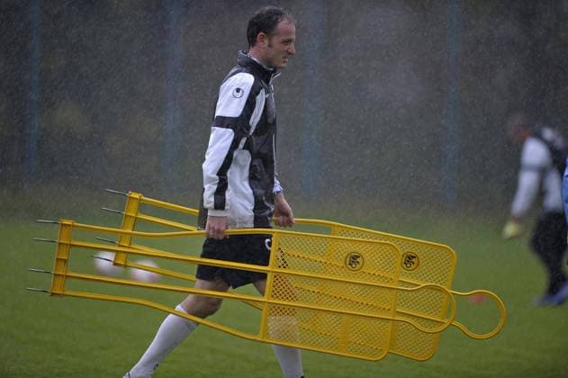 09.10.2012, Fussball 2.Bundesliga 2012 2013, TSV 1860 München Training an der Grünwalder Strasse. Co-Trainer Markus Schroth (1860) trägt Trainingsgeräte durch den starken Regen.