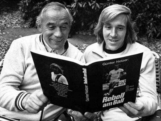 Günter Netzer (re.) zeigt Trainer Hennes Weisweiler (beide Borussia Mönchengladbach) sein Buch -Rebell am Ball-
