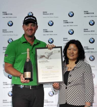Peter Hanson of Sweden, left, holds a certificate for his champion title during the award ceremony of the BMW Masters golf tournament at the Lake Malaren Golf Club in Shanghai, China, 28 October 2012.  20121028_35410