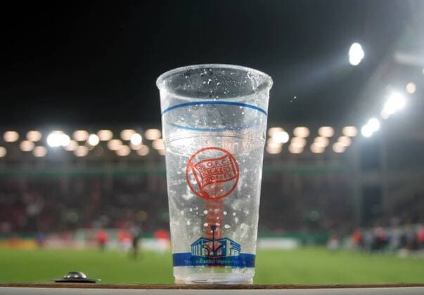 Fußball, Stadiongeschichte Kickers Offenbach DFB-Pokal, Achtelfinale, Saison 2012 2013: Kickers Offenbach - Fortuna Düsseldorf: geleerter Bierbecher aus Plastik steht auf der Werbebande vor Flutlicht im Stadion - Symbolbild für das geplante Bier- und Alkoholverbot in deutschen Fussballstadien