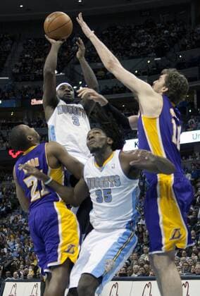 Denver Nuggets guard Ty Lawson (3) shoos against the Los Angeles Lakers Chris Duhon and Pau Gasol at the Pepsi Center on December 26, 2012 in Denver. The Nuggets stopped the Lakers winning streak with a 126-114 victory.  DEN2012122634