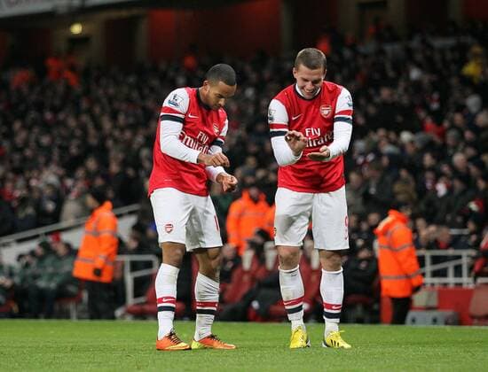 Arsenal s Theo Walcott celebrates scoring his sides fourth goal by pretending to sign his new contract..Arsenal v West Ham United - Barclays Premier League - the Emirates Stadium, London- 23 01 13 - Picture David Klein Sportimage EDITORIAL USE ONLY. No use with unauthorised audio, video, data, fixture lists, club league logos or live services. Online in-match use limited to 120 images, no video emulation. No use in betting, games or single club league player publications.