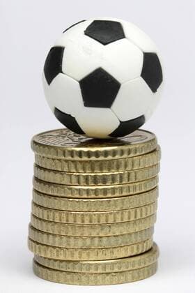 Wettskandal - Fußball liegt iauf einem Stapel von Euro Münzen