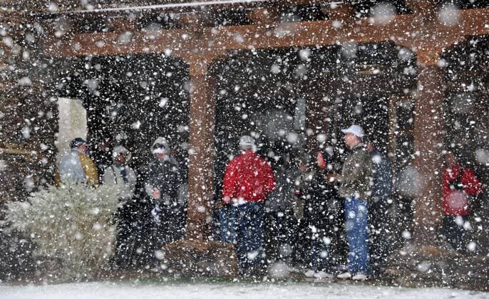 Golf fans seek shelter from the snow after the first round of the Accenture World Golf Championship at The Golf Club at Dove Mountain in Marana, Arizona was suspended February 20, 2013.  PXP2013022009