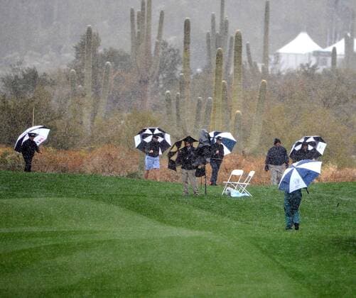 Fans make their way toward the exits as snow suspended the first round of the Accenture World Golf Championship at The Golf Club at Dove Mountain in Marana, Arizona February 20, 2013.  PXP2013022011