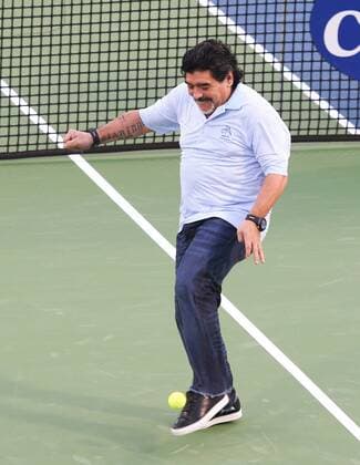 Dubai Tennis Championships 2013, ATP Tennis Herren Tennis Turnier,International Series,Dubai Tennis Stadium, U.A.E.,Fussball Legende Diego Maradona (ARG) kickt Tennisbälle ins Publikum,Einzelbild,Aktion, Ganzkörper, Hochformat,
