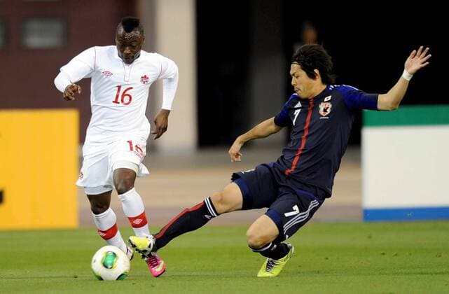 (130323) -- DOHA, March 22, 2013 (Xinhua) -- Endo Yasuhito (R) of Japan vies with Randy Edwini-Bonsu of Canada during their international friendly match at Khalifa Stadium in Doha, Qatar, on March 22, 2013. Japan won 2-1. (Xinhua Chen Shaojin) (lm) QATAR-DOHA-SOCCER-INTERNATIONAL FRIENDLY-JPN VS. CAN 