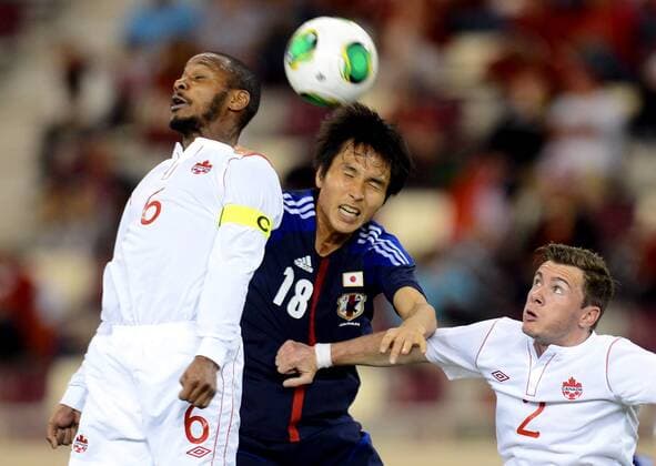 (130323) -- DOHA, March 22, 2013 (Xinhua) -- Maeda Ryoichi (C) of Japan heads with Julian De Guzman (L) of Canada during their international friendly match at Khalifa Stadium in Doha, Qatar, on March 22, 2013. Japan won 2-1. (Xinhua Chen Shaojin) (lm) QATAR-DOHA-SOCCER-INTERNATIONAL FRIENDLY-JPN VS. CAN 