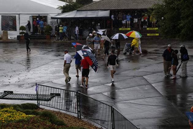 March 24, 2013 - Orlando, Florida, U.S - Spectators walk past the club house during the rain delay on the final round of the Arnold Palmer Invitational at the Bay Hill Club and Lodge. Golf 2013 - Arnold Palmer Invitational - Final Round  - ZUMAr11