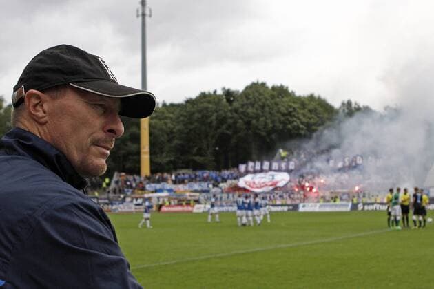 26.08.2012, AE, 3.Liga, SV Darmstadt 98 - Hansa Rostock Wolfgang Wolf (Trainer FC Hansa Rostock) schaut, wie Rostocker Fans Bengalos vor Spielbeginn abbrennen.