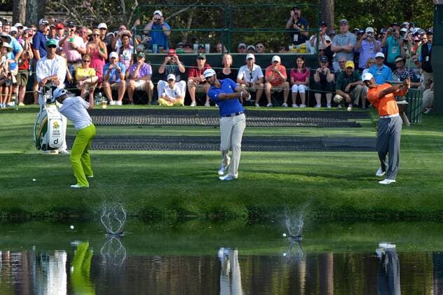 Guan Tianlang (L), Dustin Johnson (C) and Tiger Woods skip their balls across the pond on the 16th hole during a practice round before the Master golf tournament at Augusta National Golf Club on April 8, 2013 in Augusta, Georgia.  AUG20130408326