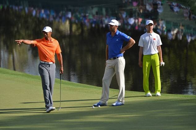 Tiger Woods (L), Dustin Johnson (C) and Guan Tianlang (L), of China, line up putts on the 16th hole during a practice round before the Master golf tournament at Augusta National Golf Club on April 8, 2013 in Augusta, Georgia.  AUG20130408342