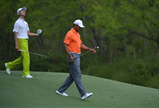 Tiger Woods and 14-year-old amateur Guan Tianlang of China walk off the 11th tee box during a practice round before the Master golf tournament at Augusta National Golf Club on April 8, 2013 in Augusta, Georgia.  AUG20130408352