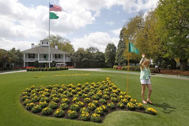 April 8, 2013 - Augusta, GA, USA - A patron poses for photos next to the Masters logo in flowers at Founders Circle in front of the Augusta National clubhouse in Augusta, Georgia, during a practice round for The Masters, Monday, April 8, 2013. Practice Round for the 2013 Masters - ZUMAm67
