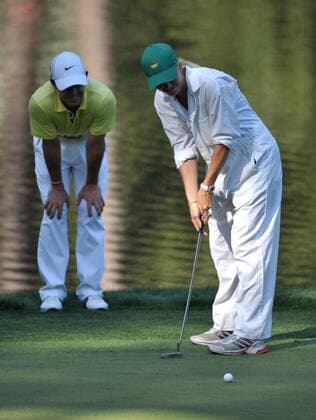 Rory McIlroy watches as his girlfriend Caroline Wozniacki putts on the 9th green during the Masters Par 3 Contest a day before the beginning of the Masters tournament at Augusta National, on April 10, 2013 in Augusta, Georgia.  AUG20130410318