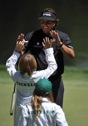 Phil Mickelson high fives his son Evan as they walk off the 9th green during the Masters Par 3 Contest, a day before the beginning of the Masters tournament, at Augusta National, on April 10, 2013 in Augusta, Georgia.  AUG20130410325