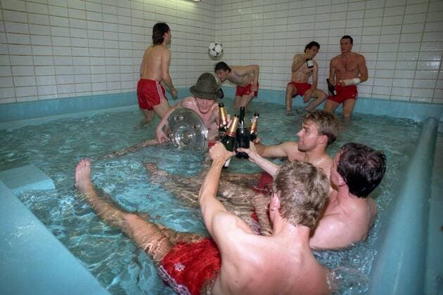 Der FC Bayern München ist deutscher Meister 1989 1990, Manfred Bender und Hansi Flick stoßen mit Sektflaschen an, Ludwig Kögl und Thomas Kastenmaier können nicht ohne Ball, Roland Grahammer und Alan McInally halten sich mit ihrem Sekt etwas abseits