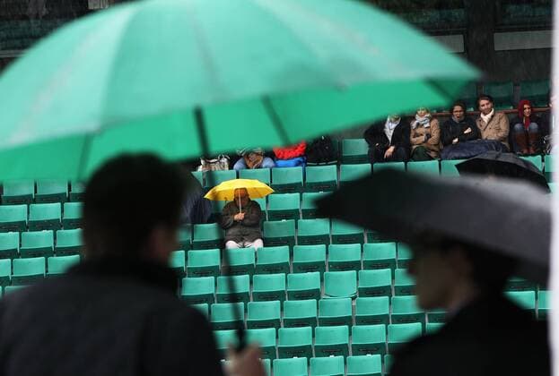 (130530) -- PARIS, May 30, 2013 (Xinhua) -- Spectators sit on the centre court as rain falls during the 2013 French Open tennis tournament at Roland Garros in Paris, France on May 30, 2013. (Xinhua Gao Jing) (hcs) (SP)FRANCE-PARIS-TENNIS-FRENCH OPEN 