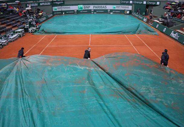 A work crew covers court 1 during a rain delay at the French Open Tennis Championship at Roland Garros in Paris on May 30, 2013.  PAR20130530734