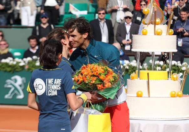 French Open 2013, Roland Garros,Paris,ITF Grand Slam Tennis Tournament, zwei Ballmädchen überreichen Geburtstagskind Rafael Nadal (ESP) eine Blumenstrauss,im Hintergrund steht die riesige Geburtstagstorte Halbkoerper,Querformat,