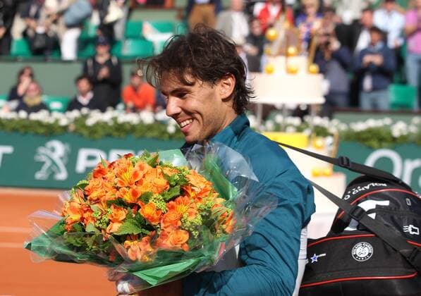 French Open 2013, Roland Garros,Paris,ITF Grand Slam Tennis Tournament, Geburtstagskind Rafael Nadal (ESP) mit Blumenstrauss,im Hintergrund steht die riesige Geburtstagstorte,Halbkoerper,Querformat,