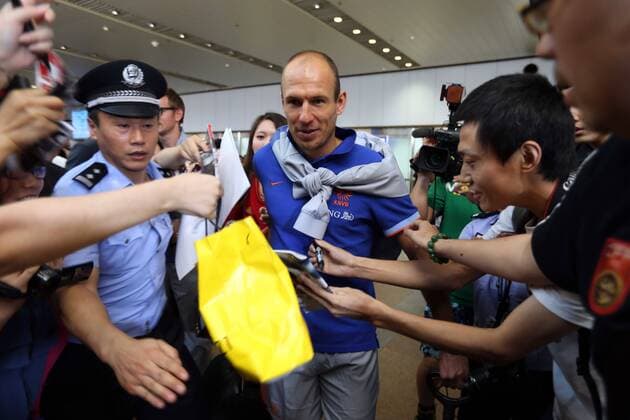 Dutch footballer Arjen Robben, center, is surrounded by Chinese fans at the Beijing Capital International Airport in Beijing, China, 8 June 2013. Team members of the Dutch national soccer team arrived in Beijing on Saturday (8 June 2013) to play a friendly match with the Chinese national team to be held on Tuesday (11 June 2013). Dutch soccer team arrives in Beijing for friendly match  20130608_08598