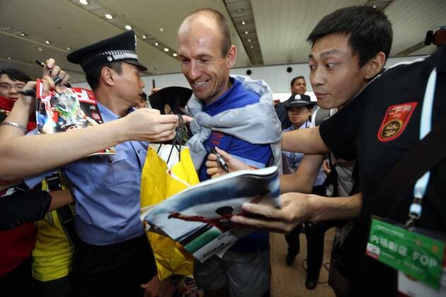 Dutch footballer Arjen Robben, center, is surrounded by Chinese fans at the Beijing Capital International Airport in Beijing, China, 8 June 2013. Team members of the Dutch national soccer team arrived in Beijing on Saturday (8 June 2013) to play a friendly match with the Chinese national team to be held on Tuesday (11 June 2013). Dutch soccer team arrives in Beijing for friendly match  20130608_28689