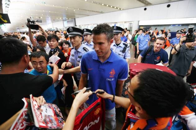 Dutch footballer Robin van Persie, center, is surrounded by Chinese fans at the Beijing Capital International Airport in Beijing, China, 8 June 2013. Team members of the Dutch national soccer team arrived in Beijing on Saturday (8 June 2013) to play a friendly match with the Chinese national team to be held on Tuesday (11 June 2013). Dutch soccer team arrives in Beijing for friendly match  20130608_45377