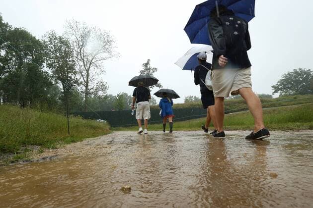 June 10 2013: Heavy rains flood the pathways as fans walk threw the water during monday s practice round at the 2013 U.S. Open hosted by Merion Golf Club in Ardmore, PA. GOLF: JUN 10 PGA Golf Herren - U.S. Open - Monday Practice Round Icon131831 EDITORIAL USE ONLY