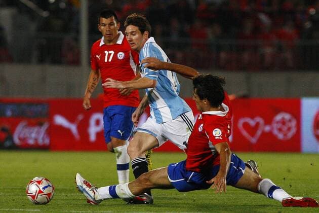 16 10 2012 Football, Chile vs Argentina. Argentinean national team player Lionel Messi, left, battles for the ball against Chile s Marcos Gonzalez during their qualifying to Brazil 2014 football match held at National stadium in Santiago, Chile. 16 10 2012 Futbol, Chile vs Argentina. 