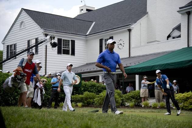 Tiger Woods (C), Rory McIlroy (2nd-L), Tiger Woods caddie Joe LaCava (L) and Adam Scott walk off the first tee box at the start of their round during the first round of the 113th U.S. Open Championship at Merion Golf Club in Ardmore, Pennsylvania on June 13, 2013.  PHI20130613344