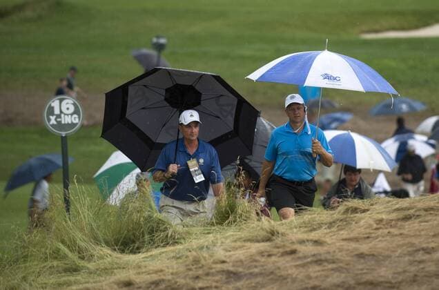 Golf fans leave the course after play was suspended for a second time today due to weather during the first round of the 113th U.S. Open Championship at Merion Golf Club in Ardmore, Pennsylvania on June 13, 2013.  PHI20130613353