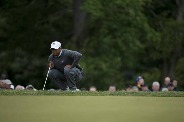 Tiger Woods lines up a putt on the 18th green during the continuation of the first round of the 113th U.S. Open Championship at Merion Golf Club in Ardmore, Pennsylvania on June 14, 2013.  PHI20130614302
