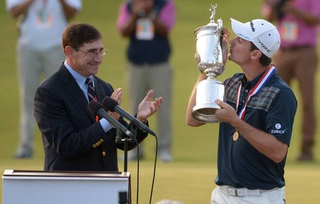 Justin Rose kisses the USA Open Championship Trophy as USGA Commissioner Glen Nager applauds after Rose won the 113th U.S. Open Championship at Merion Golf Club in Ardmore, Pennsylvania on June 16, 2013.  PHI20130616316
