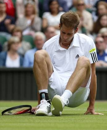 Florian Mayer of Germany falls down during the first round of men s singles on day 2 of the Wimbledon Lawn Tennis Championships at the All England Lawn Tennis and Croquet Club in London, Britain, on June 25, 2013. 