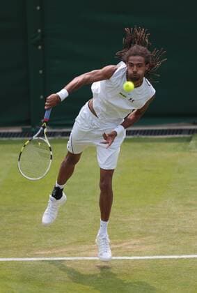 Germany s Dustin Brown serves in his match on day three of the 2013 Wimbledon Championships in London on June 26, 2013.  LON2013062607