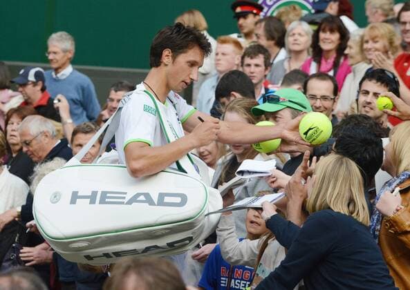 Tennis - 2013 Wimbledon Championships - Mens Singles second Round on Centre Court Sergiy Stakhovsky signs autographs after victory 