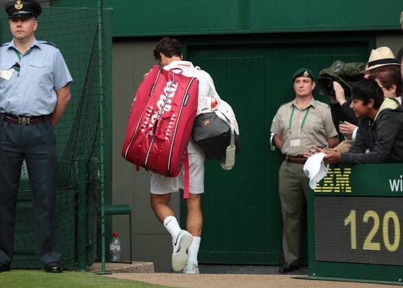 Roger Federer leaves Center Court after being defeated by Ukranian Sergiy Sakhovsky on day three of the 2013 Wimbledon Championships in London on June 26, 2013.  LON2013062627
