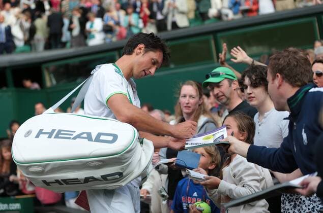 Ukranian Sergiy Stakhovsky signs autographs after his win over Roger Federer on day three of the 2013 Wimbledon Championships in London on June 26, 2013.  LON2013062630