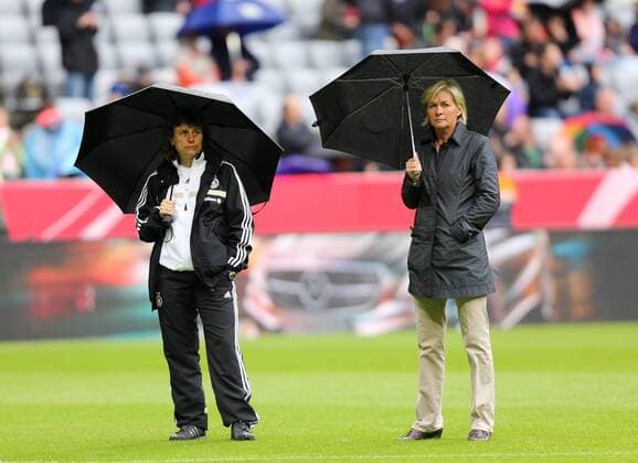 München Fußball Frauen Deutschland vs. Japan, v.l. Co-Trainerin Ulrike Ballweg und Trainerin Silvia Neid (GER) mit Regenschirmen