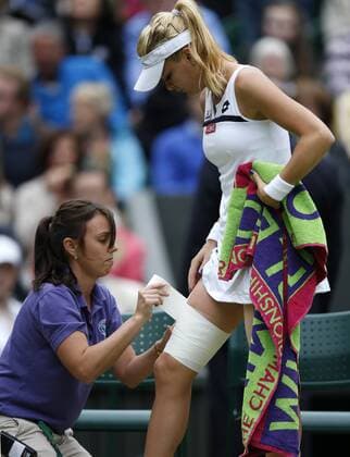 LONDON, July 2, 2013 -- Agnieszka Radwanska (R) of Poland receives the medical treatment during the quarterfinal of women s singles on day 8 of the Wimbledon Lawn Tennis Championships at the All England Lawn Tennis and Croquet Club in London, Britain on July 2, 2013. 