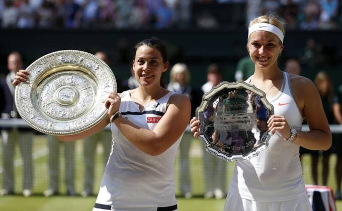 (130706) -- LONDON, July 6, 2013 (Xinhua) -- Marion Bartoli (L) of France shows the trophy with Sabine Lisicki of Germany during the awarding ceremony for the final of women s singles on day 12 of the Wimbledon Lawn Tennis Championships at the All England Lawn Tennis and Croquet Club in London, Britain, on July 6, 2013. 