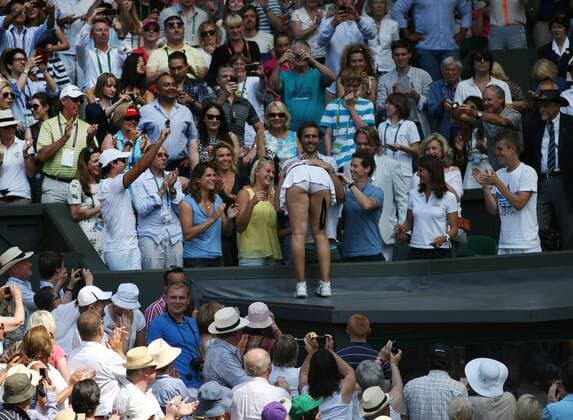 Marion Bartoli climbs into the player s box, with Amelie Mauresmo and Kristina Mladenovic, in the Women s Final of the 2013 Wimbledon Championships in London on July 6, 2013.  LON2013070616
