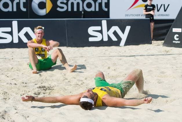 07.07.2013, Beachvolleyball, Smart Beach Cup Köln, v.l. Erschöpft lassen sich Alexander Walkenhorst (KMTV Eagles) und Sebastian Prüsener (General Unterhaching) nach dem Sieg fallen