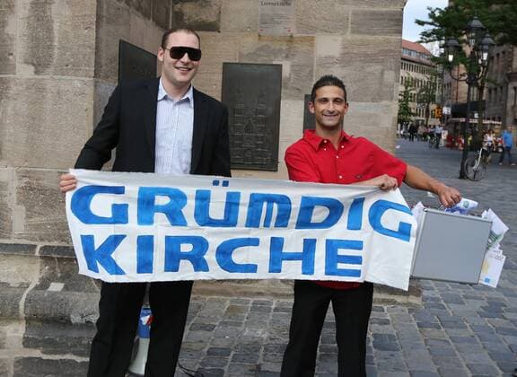 12.07.2013 - Fussball - Saison 2013 2014 - Flashmob in Nürnberger Innenstadt - Grundig Stadion - Max-Morlock-Stadion - 1. FC Nürnberg FCN - Stadt Nürnberg Ultras Nürnberg 1994 UN UN94 - DaMa - Fans des FCN versteigern Symbolisch die Namen bekannter Sehenwürdigkeiten in der Nürnberger Innenstadt - vor der Lorenzkirche - und geben diesen neue Namen: Grümdig-Kirche
