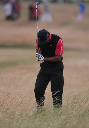 USA s Tiger Woods shows emotion in the rough on the eleventh hole on the fourth day of the 2013 Open Championship in Muirfield, Scotland on July 21 , 2013.Phil Mickelson won the championship with a score of three under par.  LON2013072112