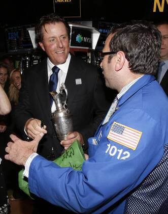 Phil Mickelson signs autographs while holding the Claret Jug when he stands on the floor of the New York Stock Exchange after he and executives from the Mickelson ExxonMobil Teachers Academy ring the closing bell at the NYSE on Wall Street In New York City on July 26, 2013. In its ninth year, the Mickelson ExxonMobil Teachers Academy is a week-long professional development program where third- through fifth-grade teachers hone their math and science skills and learn ways to excite and inspire their students in these subjects.  NYP20130726140